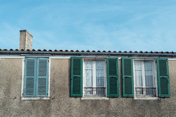 une façade de maison à Oléron avec une cheminée et des fenêtres