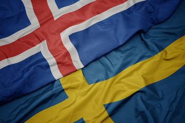 waving colorful flag of sweden and national flag of iceland.