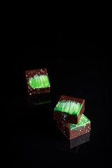 Art colorful chocolate candies on black background, selected focus