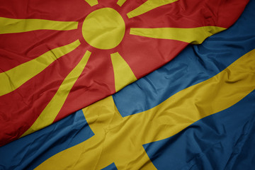 waving colorful flag of sweden and national flag of macedonia.
