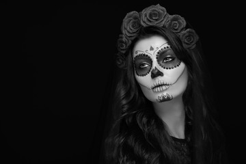Portrait of a woman with sugar skull makeup over black background. Halloween costume and make-up....