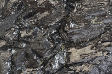Close-up view of coal mine. Raw coal ore surface close-up. Natural black coal bar for background. Industrial coal nuggets close up.