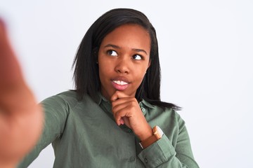 Beautiful young african american woman taking selfie over isolated background serious face thinking about question, very confused idea