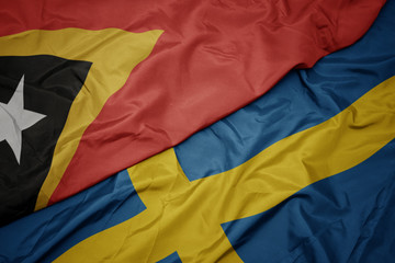 waving colorful flag of sweden and national flag of east timor.