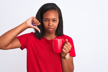 Young african american woman drinking a cup of coffee over isolated background with angry face,...