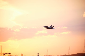 Fototapeta na wymiar Australian Air Force fighter jet flying through Brisbane at sunset