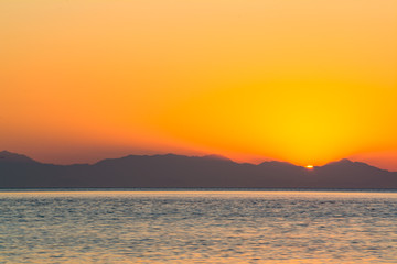 Fototapeta na wymiar Pomarańczowe niebo i wschód słońca nad górami.