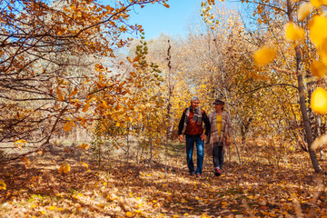 Fototapeta premium Fall activities. Senior couple walking in autumn park. Middle-aged man and woman hugging and chilling outdoors