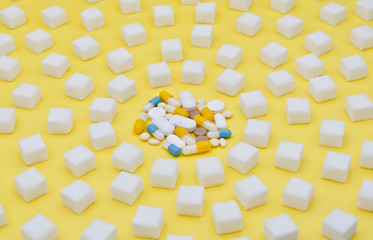 Pills surrounded by sugar cubes