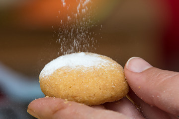 Fototapeta premium Pouring powdered sugar on a Christmas cookie