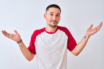 Young handsome man standing over isolated background clueless and confused expression with arms and hands raised. Doubt concept.