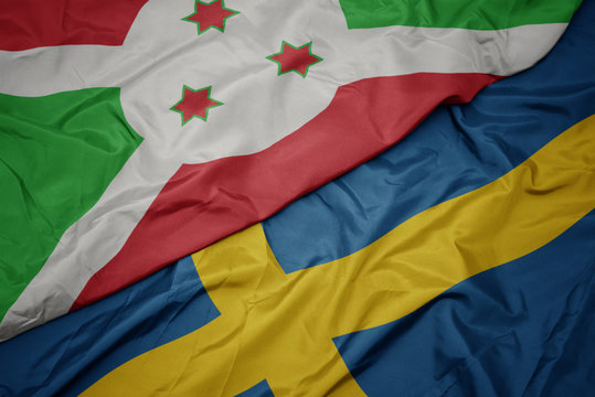 waving colorful flag of sweden and national flag of burundi .