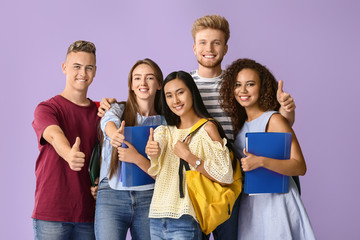 Group of students showing thumb-up gesture on color background