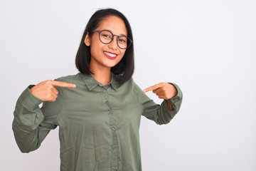 Young chinese woman wearing green shirt and glasses over isolated white background looking...