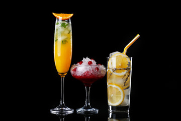Different tasty cocktails on dark background
