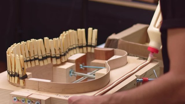 Guitar maker glues half lining on acoustic guitar