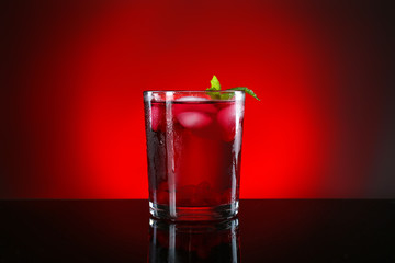 Glass of tasty cocktail on dark color background