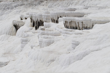Fototapeta na wymiar Pamukkale in Turkey is known for its mineral-rich thermal waters flowing down white travertine terraces. Pamukkale is nicknamed the cotton castle because of its white appearance.