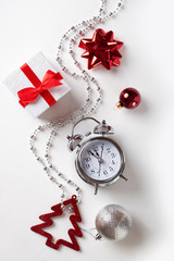 New year or Christmas holiday composition. Gift box, New year balls, clock. Vertical shot.