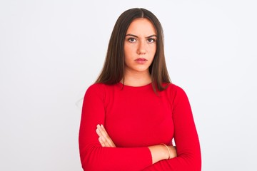 Young beautiful girl wearing red casual t-shirt standing over isolated white background skeptic and nervous, disapproving expression on face with crossed arms. Negative person.