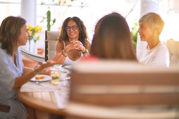 Young beautiful girl smiling happy and confident sitting dinking cup of coffee at terrace