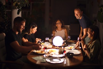 Beautiful family on dinner talking and smiling at terrace