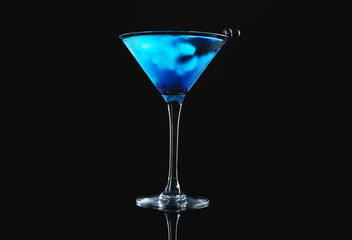 Glass of tasty cocktail on dark background