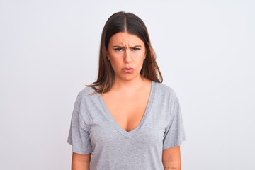 Portrait of beautiful young woman standing over isolated white background skeptic and nervous, frowning upset because of problem. Negative person.