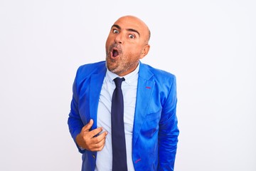 Middle age businessman wearing suit standing over isolated white background confuse and wondering about question. Uncertain with doubt, thinking with hand on head. Pensive concept.