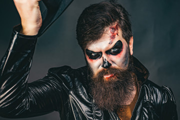 Happy Halloween - handsome vampire isolated on dark background. Halloween party and holiday concept. Vampire man with bloody eyes. Scary hipster with beard in Halloween hat.