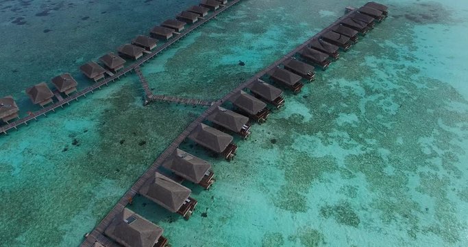Aerial view of over-water villas in Maldives. Luxury hotel and spa resort on Maldivian island with white sand and turquoise crystal clear water. Famous place for honeymoon