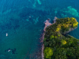 Aerial view of Mogren promontory between the Mogren beaches. Budva. Montenegro. Jagged coasts with sheer cliffs overlooking the transparent sea. Wild nature and Mediterranean maquis