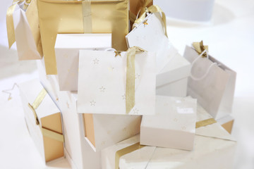 Christmas white gift bags with gold ribbons and stars, holiday gift wrapping