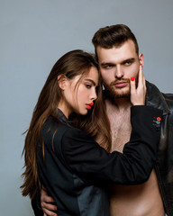 Man brutal well groomed macho and attractive feminine girl long hair cuddling. Girlfriend passionate red lips and man leather jacket. Passionate hug. Couple passionate people in love. Passion fashion