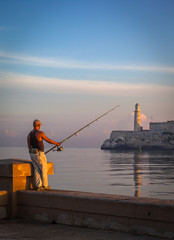 Cuban man fishing in front of the famous fortress of El Morro, Havana, Cuba