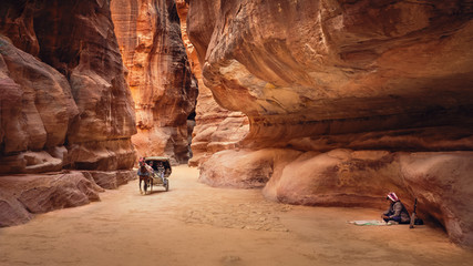 The Siq with a horse-drawn cart for transporting tourists and a rababa player, Petra, Jordan