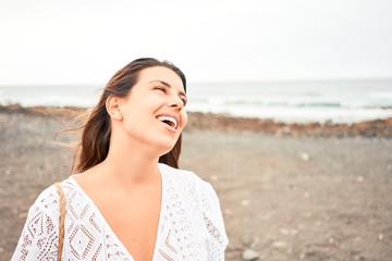 Fototapeta na wymiar Young beautiful woman smiling happy enjoying summer vacation at black sand beach at Canary Islands