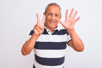 Senior grey-haired man wearing casual striped polo standing over isolated white background showing and pointing up with fingers number seven while smiling confident and happy.