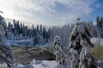 Water flows over the top of Pisew Falls on a cold winter day, Manitoba, Canada