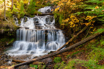 Fototapeta na wymiar waterfall in the forest surrounded by fall foliage