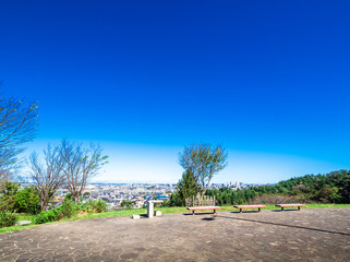青空と丘の上のベンチ