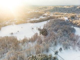 Beautiful aerial view of snow covered pine forests. Rime ice and hoar frost covering trees. Scenic winter landscape in Vilnius, Lithuania.