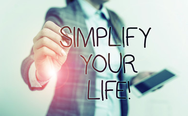 Text sign showing Simplify Your Life. Business photo text focused on important and let someone else worry about less ones Business woman pointing in empty space with pen and mobile phone