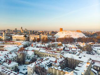 Fototapeta na wymiar Beautiful Vilnius city panorama in winter with snow covered houses, chruches and streets. Aerial evening view.
