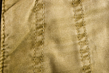 clothing items stonewashed cotton fabric texture with seams, clasps, buttons and rivets, macro