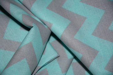 Green textile, fabric with a zigzag pattern, close-up photo.