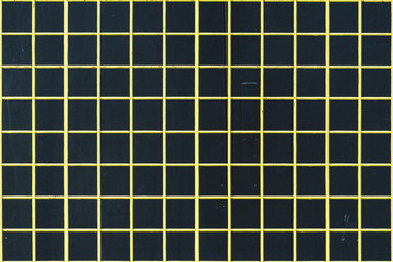 Yellow strong wire mesh fencing against black background.