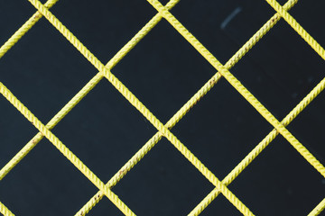 Yellow Metal Fence against Black Background.
