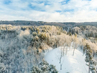 Fototapeta na wymiar Beautiful aerial view of snow covered pine forests. Rime ice and hoar frost covering trees. Scenic winter landscape in Vilnius, Lithuania.