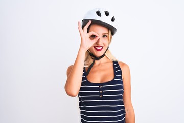 Young beautiful woman wearing bike helmet standing over isolated white background doing ok gesture with hand smiling, eye looking through fingers with happy face.